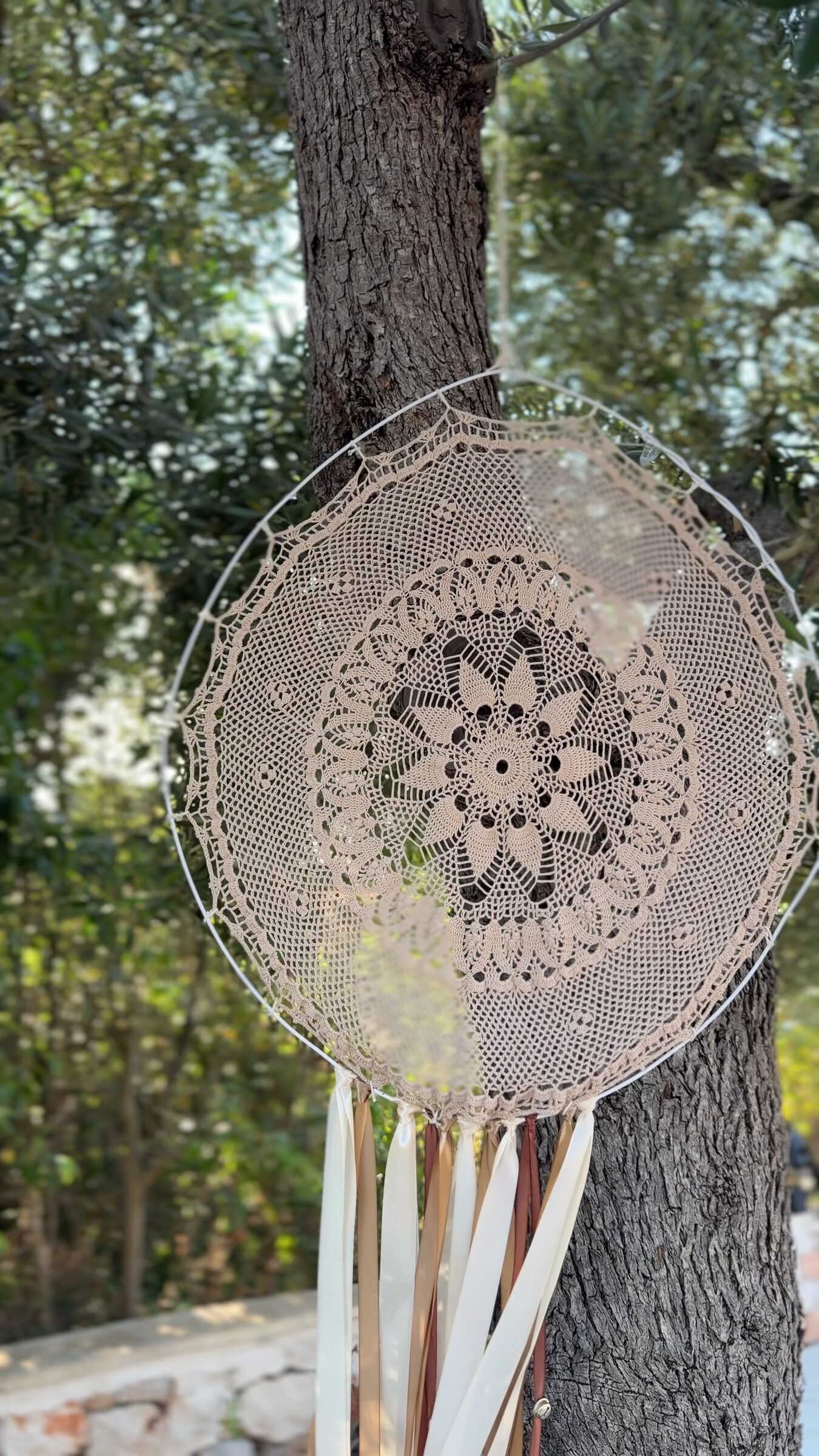 Mandala di pizzo appeso a un ulivo nel boschetto