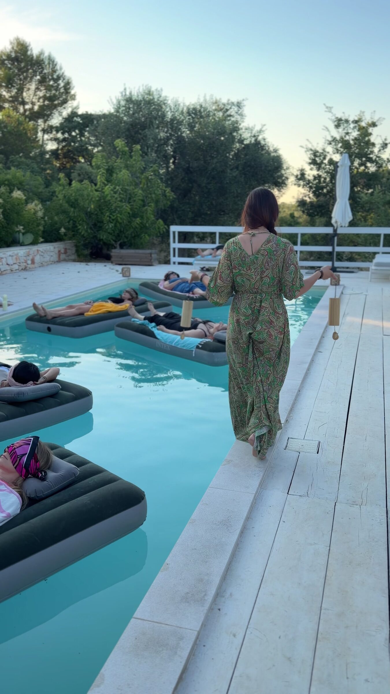 Passeggiata lungo il bordo piscina tra i lettini al tramonto